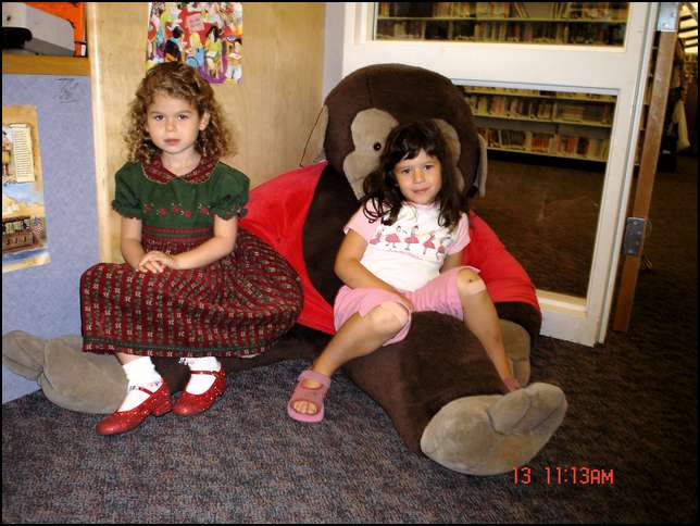 Ava and Sydney sitting on Curious George