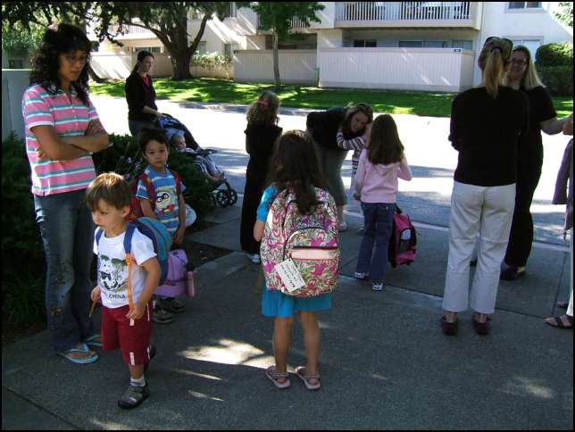 about 10 children waiting for the school bus